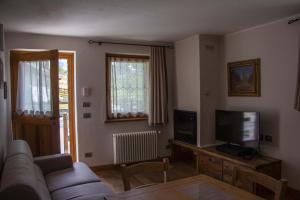 a living room with a couch and a tv at Maison Carrel Elegant 8 in Breuil-Cervinia