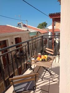 a table with a bowl of fruit on a balcony at Stylish home - comfortable holidays near the beach. in Panormos Rethymno