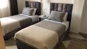 a hotel room with two beds and a table at riad casa bahia asilah in Asilah
