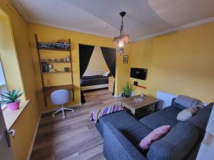 a living room with a blue couch and a table at Ásgarður in Hrísey