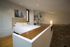 a bedroom with a bed with a wooden counter top at Apartamentos Turísticos Pacios in Santiago de Compostela