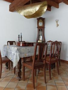 a dining room with a table and a grandfather clock at Chambre Cassis in Arles