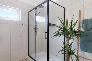 une douche avec une porte en verre à côté d'une plante dans l'établissement Casa Kiko, à Anha