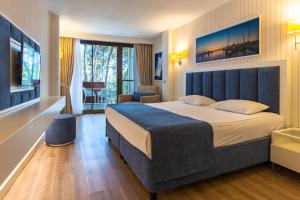 a hotel room with a large bed and a chair at MIRADA DEL MAR HOTEL in Antalya