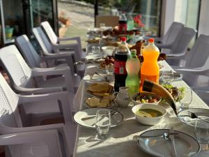 a long table with plates of food and drinks on it at Guest House ETM in Makhinjauri