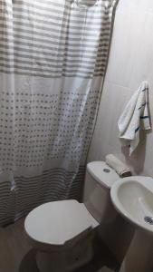 y baño con aseo blanco y lavamanos. en Cabaña villa lola en San Gil