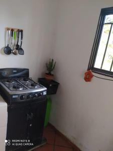 cocina con fogones y ventana en Cabaña villa lola en San Gil