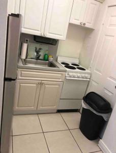 a small kitchen with a sink and a stove at Steps to the beach! in Miami Beach
