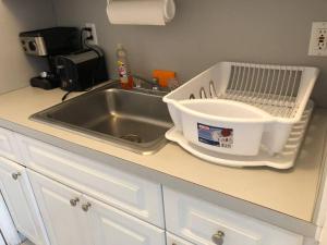 a kitchen sink with a dish drying rack next to it at Steps to the beach! in Miami Beach