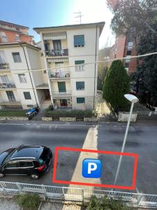 une voiture garée dans un parking en face d'un bâtiment dans l'établissement Lemon House YELLOW, à Pise