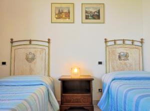 1 dormitorio con 2 camas y una vela sobre una mesa en La Casa di Sciano, en Certaldo