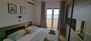 a bedroom with a bed with a view of the ocean at Apartments Del Mare in Crikvenica