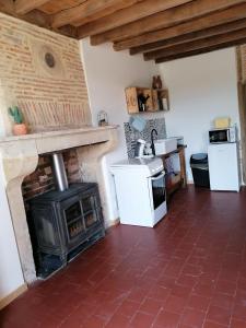a kitchen with a fireplace and a stove at chez Marie et Lulu 