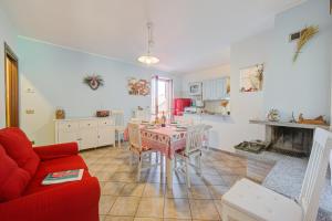 ein Wohnzimmer mit einem Tisch und einem roten Sofa in der Unterkunft Brighty Rainbow House Garden - Happy Rentals in Armeno