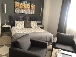 a bedroom with a bed and a chair at riad casa bahia asilah in Asilah
