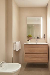 ein Badezimmer mit einem Waschbecken, einer Badewanne und einem Spiegel in der Unterkunft Easo Suite 2B by FeelFree Rentals in San Sebastián