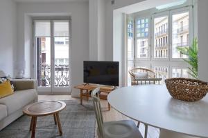 ein Wohnzimmer mit einem Tisch und einem Sofa in der Unterkunft Easo Suite 2B by FeelFree Rentals in San Sebastián