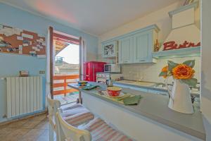 eine Küche mit einer Theke mit einer Vase mit einer Blume darauf in der Unterkunft Brighty Rainbow House Garden - Happy Rentals in Armeno