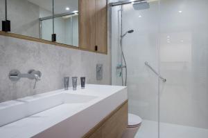 a bathroom with a white sink and a shower at Apartament Premium PINEA 205 in Pobierowo