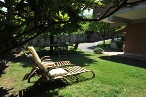 two lawn chairs sitting in the grass in a yard at Bonavia B&B in Sistiana