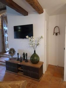 a vase with flowers on a table in a room at L Estello, Village house in Provence in Seillans