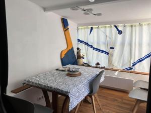 mesa de comedor y sillas en una habitación con ventana en Petite maison de pêcheur en Ile aux Moines