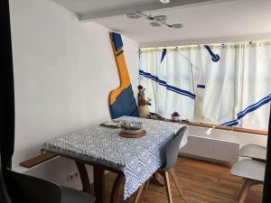 - une table à manger et des chaises dans une pièce avec fenêtre dans l'établissement Petite maison de pêcheur, à l'Île-aux-Moines