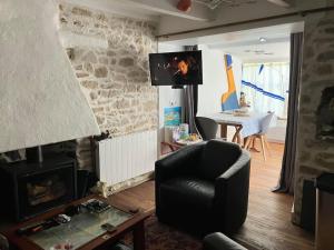 sala de estar con silla y chimenea en Petite maison de pêcheur en Ile aux Moines