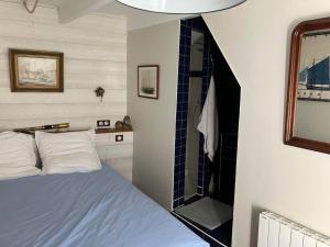 a bedroom with a bed and a walk in shower at Petite maison de pêcheur in Ile aux Moines