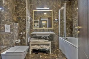 a bathroom with a sink and a toilet and a tub at Hotel Cvita in Split