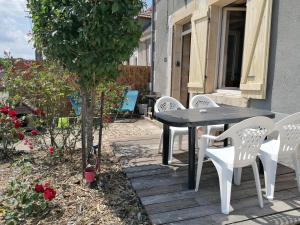 a black table and white chairs on a patio at chez Marie et Lulu in Dompierre-sur-Nièvre