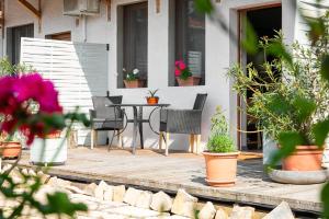 un patio con tavolo, sedie e piante in vaso di Patakpart Vendégház a Egerszalók