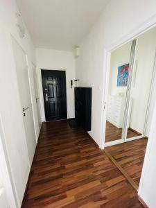 un couloir vide avec une porte noire et du parquet dans l'établissement MEXY apartment, à Košice