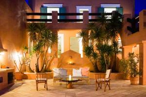d'une terrasse avec un canapé, des chaises et une table. dans l'établissement Exquisite beachfront mansion, à Ermoúpoli