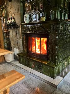 a stone fireplace in a room with a wooden table at Mała Bawaria in Zakopane