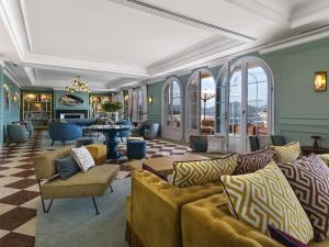 a living room with yellow couches and chairs at Althoff Hotel Villa Belrose in Saint-Tropez