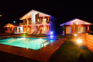 a house with a swimming pool at night at Coastal Republica in Gokarna