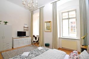 Schlafzimmer mit einem Bett, einem Schreibtisch und einem Fenster in der Unterkunft City Center Apartments in Prag
