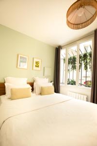 a bedroom with a large white bed with white pillows at Edgar Suites Martyrs - Lebas in Paris