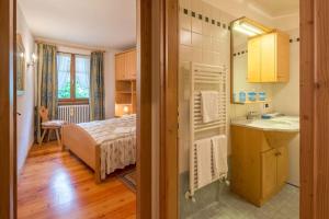 - une chambre avec un lit et une salle de bains pourvue d'un lavabo dans l'établissement Cozy apartment near Cortina, à San Vito di Cadore