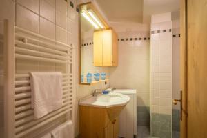La petite salle de bains est pourvue d'un lavabo et d'un miroir. dans l'établissement Cozy apartment near Cortina, à San Vito di Cadore