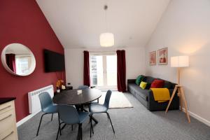uma sala de estar com uma mesa e um sofá em Harrogate Self Catering - Regent's Court Cherry Suite em Harrogate
