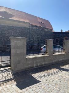 une clôture en pierre avec une porte en face d'un bâtiment dans l'établissement U Wewody Fridlantskeho, à Frýdlant