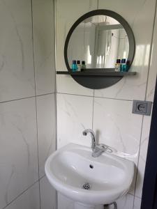 La salle de bains est pourvue d'un lavabo blanc et d'un miroir. dans l'établissement Ayas Apart, à Macka