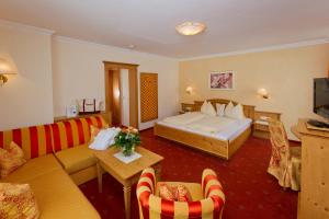 pokój hotelowy z łóżkiem i kanapą w obiekcie Hotel Taxerhof w mieście Radstadt