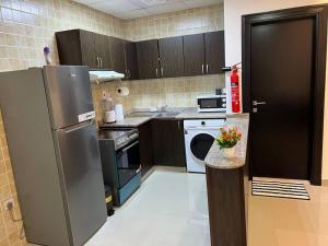 uma cozinha com um frigorífico de aço inoxidável e uma máquina de lavar louça em Spacious Cozy Brand New 1 Bedroom Apartment em Dubai