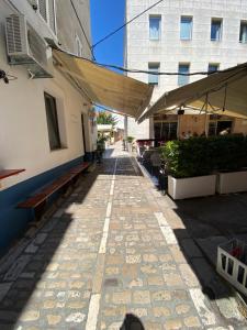 an empty sidewalk with benches and a building at Ada in Zadar
