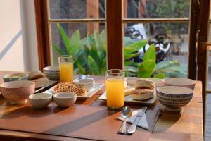 una mesa de madera con productos para el desayuno y zumo de naranja en Verde Madera Hostel B&B en Santiago