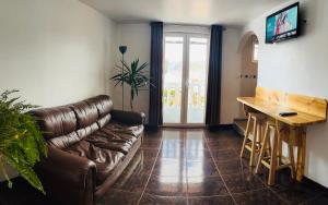 un soggiorno con un divano in pelle e un tavolo di Sambleña a Cuzco