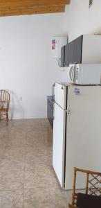 eine Küche mit einem Kühlschrank sowie einem Tisch und Stühlen in der Unterkunft Posada Atardeceres in Puan
